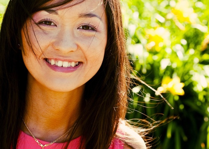 woman in pink blouse smiles