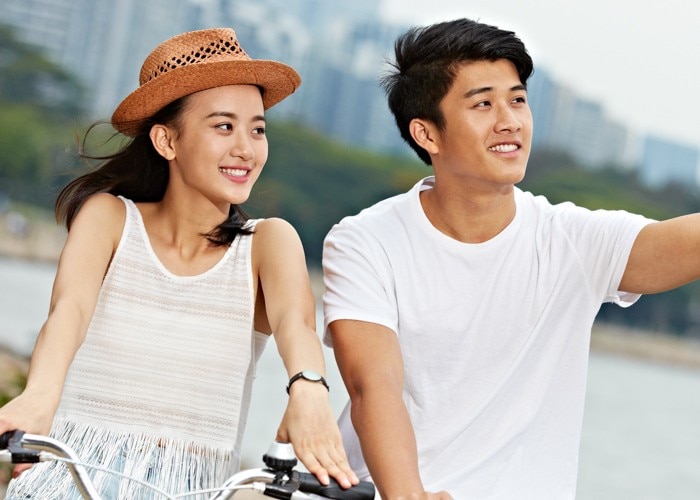 asian woman and man riding bike
